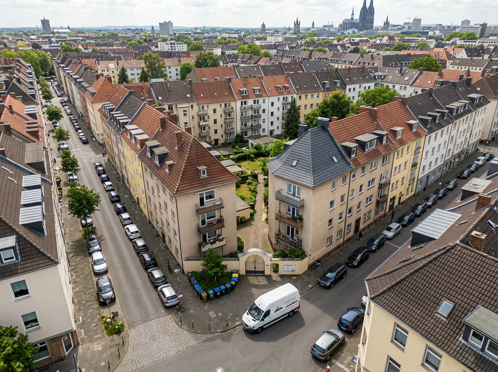 Luftaufnahme eines Kölner Wohnviertels mit Dächern, Straßen und Catering-Van.